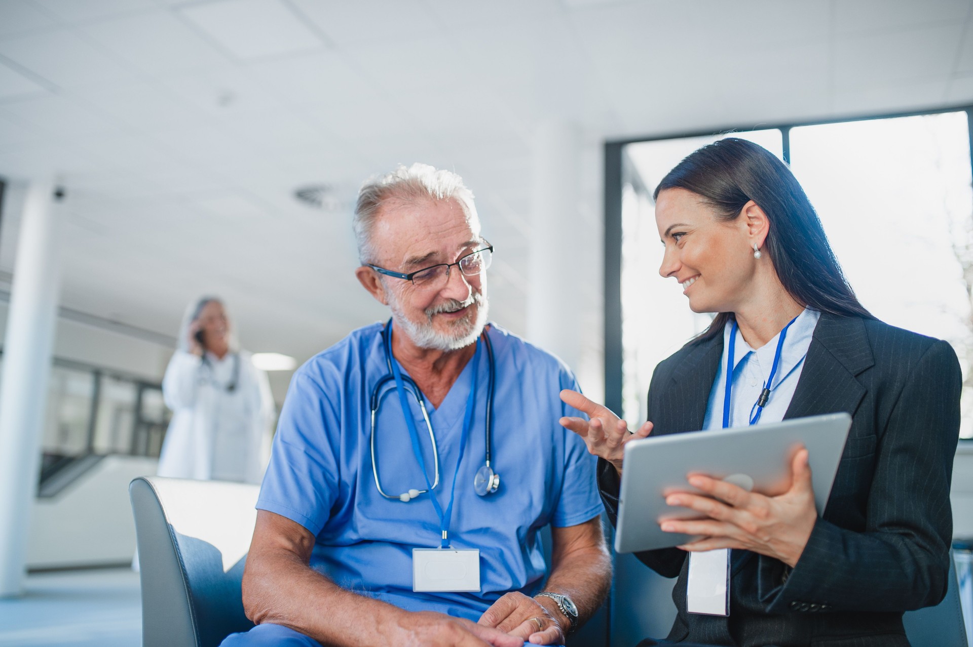 Young business woman shaking hand with elderly doctor.